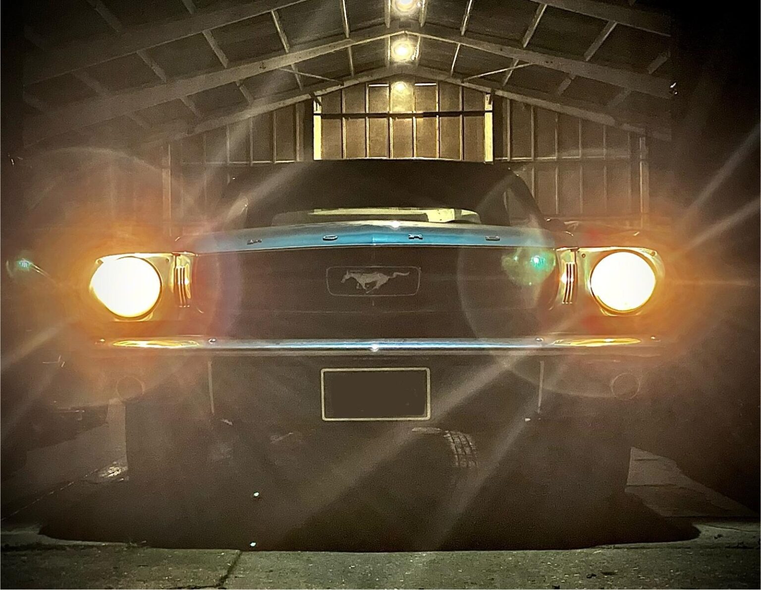 Classic Ford Mustang with its headlights on at the entrance to our storage unit