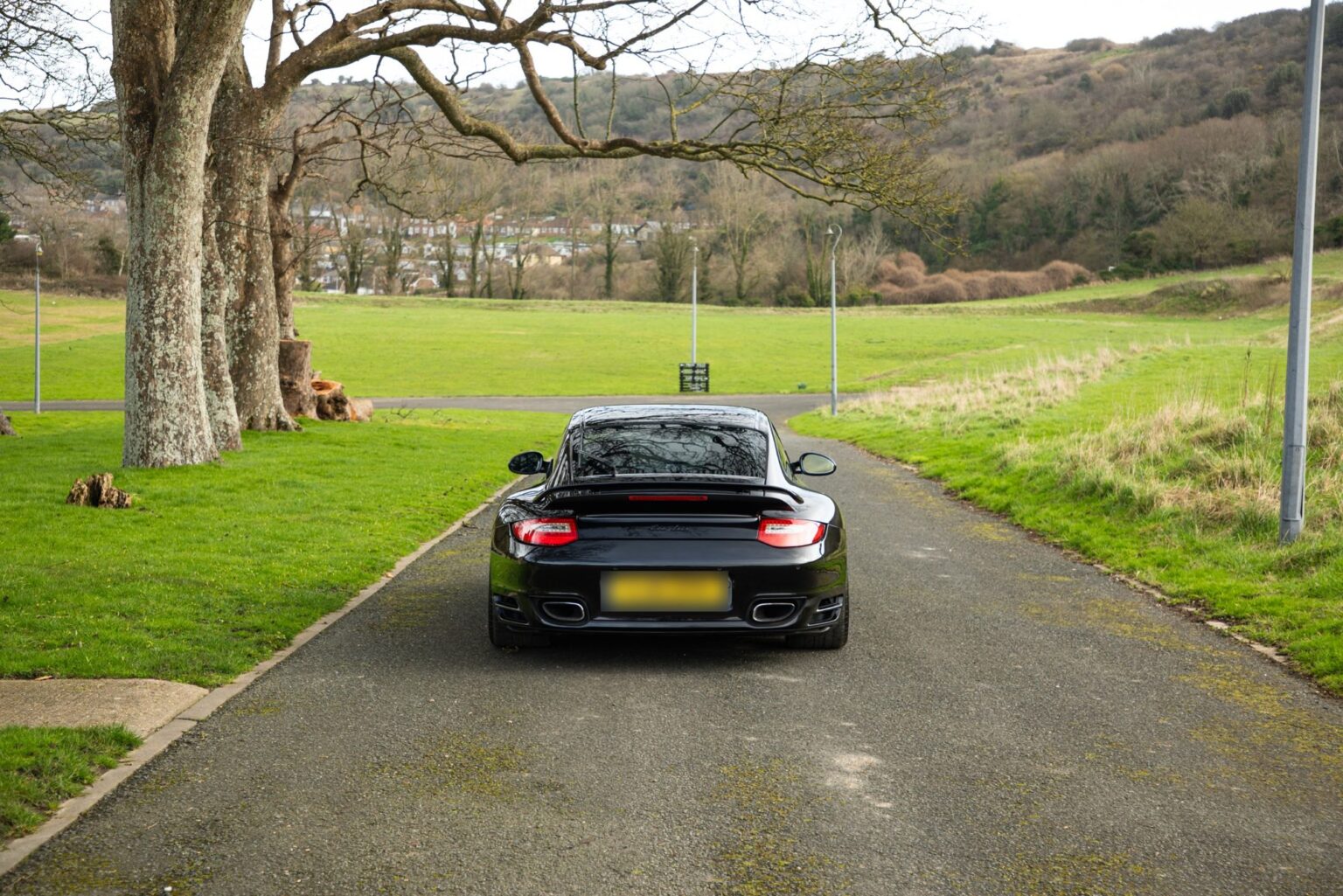 Black Porsche 911 Turbo on a private road